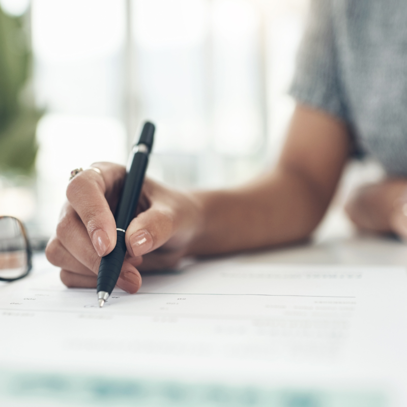 Person with pen writing on paper